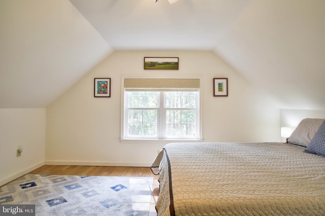 bedroom featuring lofted ceiling, light wood-style floors, and baseboards