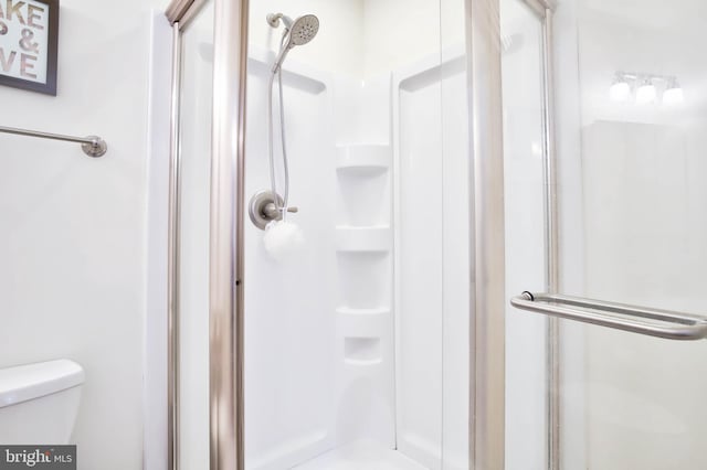 bathroom with a shower stall and toilet
