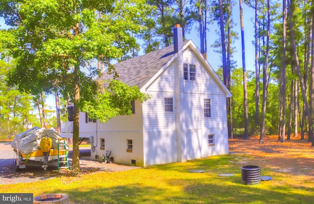 view of property exterior featuring a yard and a shingled roof