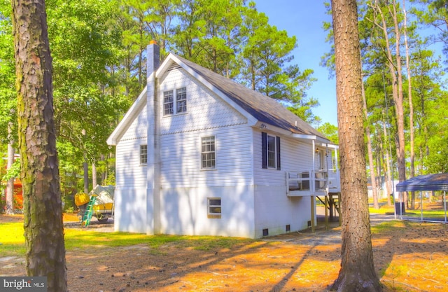 view of side of home featuring a chimney and a deck