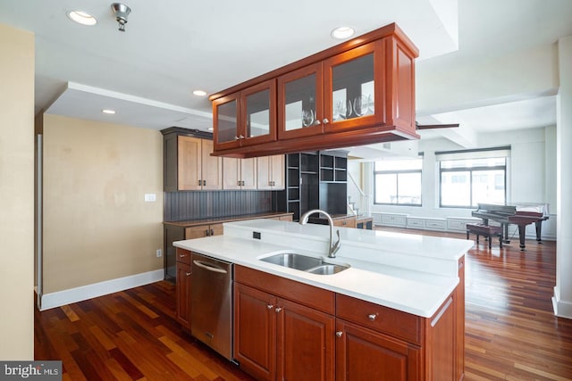 kitchen featuring tasteful backsplash, an island with sink, stainless steel dishwasher, dark wood-type flooring, and sink