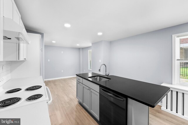 kitchen with dishwasher, light hardwood / wood-style floors, sink, white electric range, and a kitchen island with sink