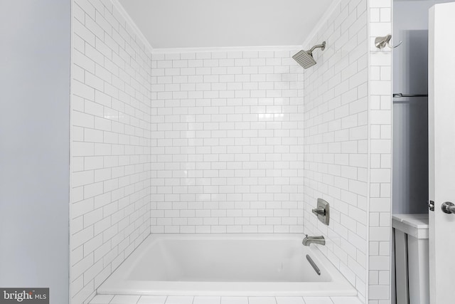 bathroom with crown molding and tiled shower / bath