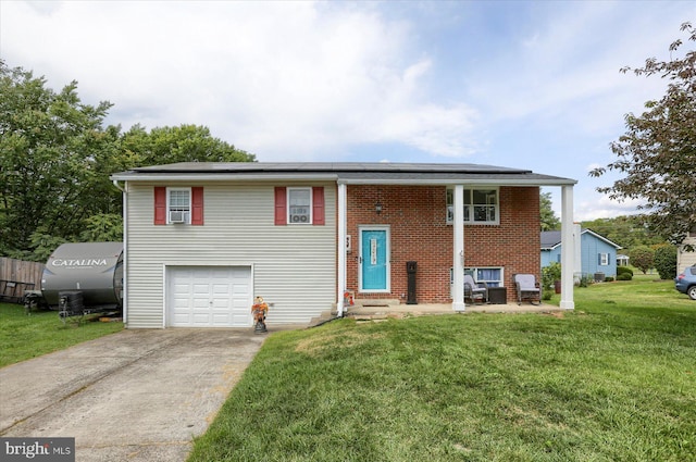 split foyer home featuring a front lawn, concrete driveway, a garage, brick siding, and solar panels