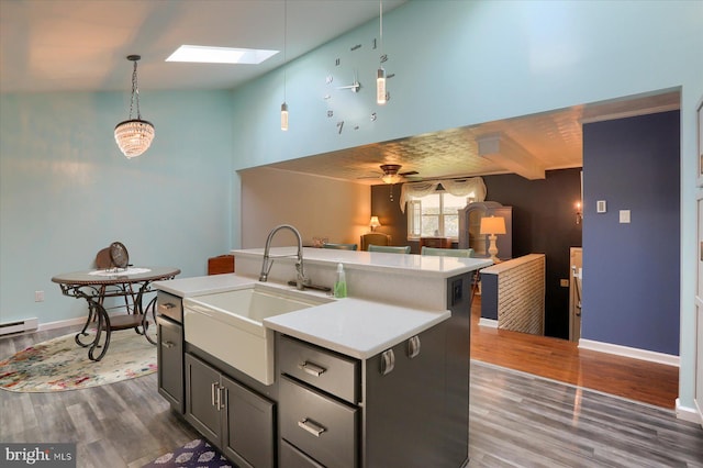 kitchen with a skylight, ceiling fan, dark hardwood / wood-style floors, and sink