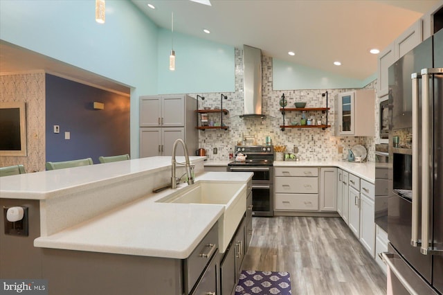 kitchen featuring stainless steel appliances, gray cabinetry, decorative backsplash, and a breakfast bar area