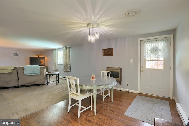 dining room featuring a baseboard radiator, dark hardwood / wood-style floors, a notable chandelier, and heating unit