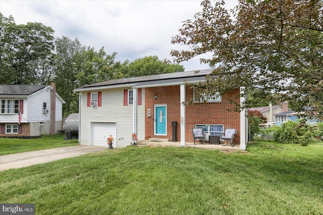 bi-level home with solar panels, a front lawn, brick siding, and driveway