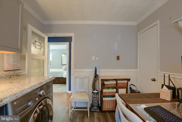 bedroom featuring light wood-type flooring, washer / dryer, ensuite bathroom, and ornamental molding