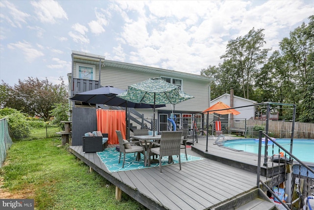 rear view of property with a yard and a pool side deck