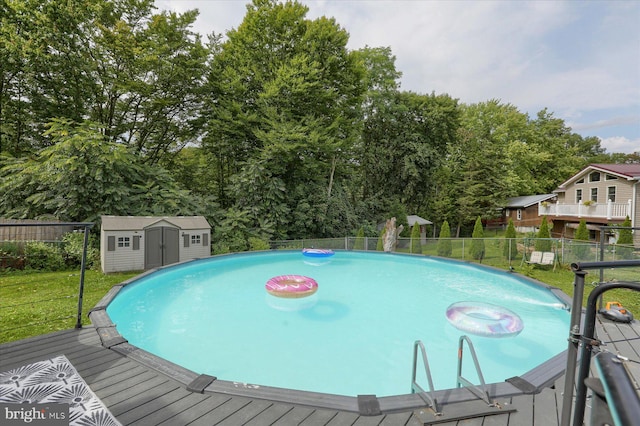 view of swimming pool featuring a yard, a storage shed, and a deck