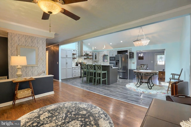 living room with ceiling fan, ornamental molding, and wood-type flooring