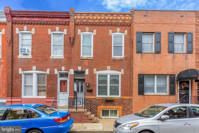 view of property featuring brick siding and cooling unit