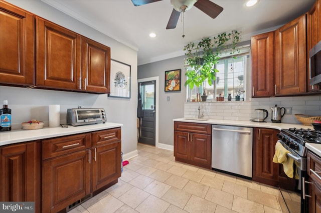 kitchen featuring ornamental molding, stainless steel appliances, sink, ceiling fan, and decorative backsplash