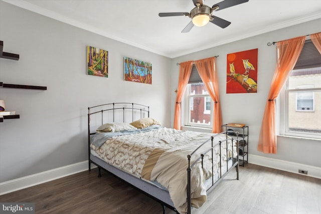 bedroom with ceiling fan, wood-type flooring, and multiple windows