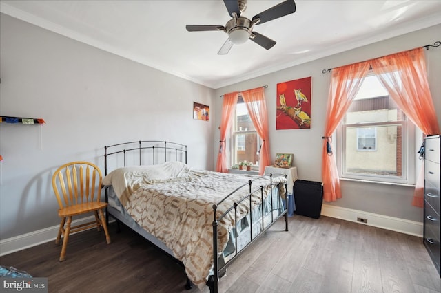 bedroom featuring ornamental molding, multiple windows, hardwood / wood-style floors, and ceiling fan