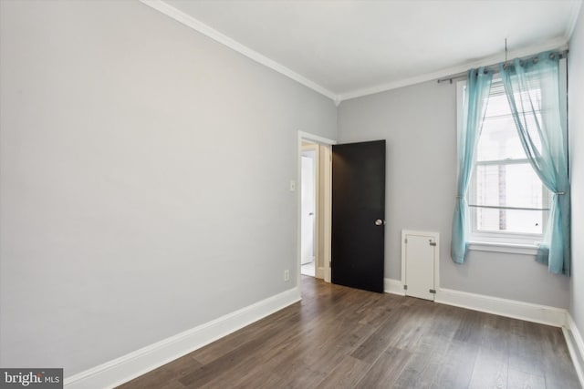 spare room with dark wood-type flooring and ornamental molding