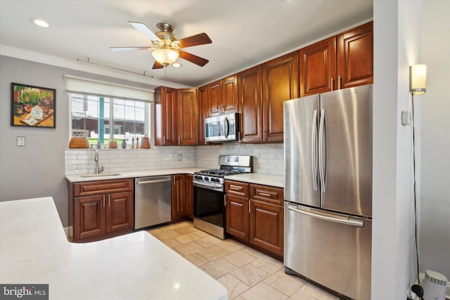 kitchen with backsplash, appliances with stainless steel finishes, ornamental molding, sink, and ceiling fan