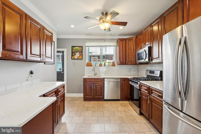 kitchen featuring appliances with stainless steel finishes, crown molding, sink, decorative backsplash, and ceiling fan