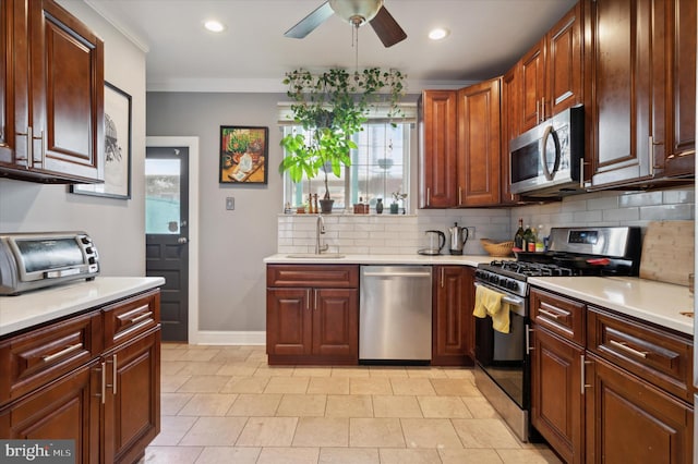 kitchen featuring appliances with stainless steel finishes, sink, ceiling fan, tasteful backsplash, and ornamental molding