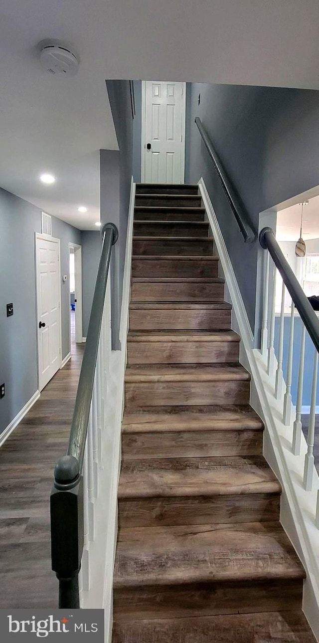 stairs featuring hardwood / wood-style floors