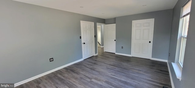 unfurnished bedroom with dark wood-type flooring