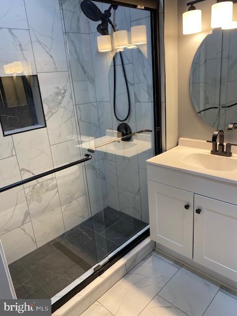 bathroom featuring vanity and a shower with shower door