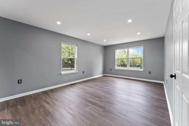 unfurnished room with dark hardwood / wood-style floors and a healthy amount of sunlight