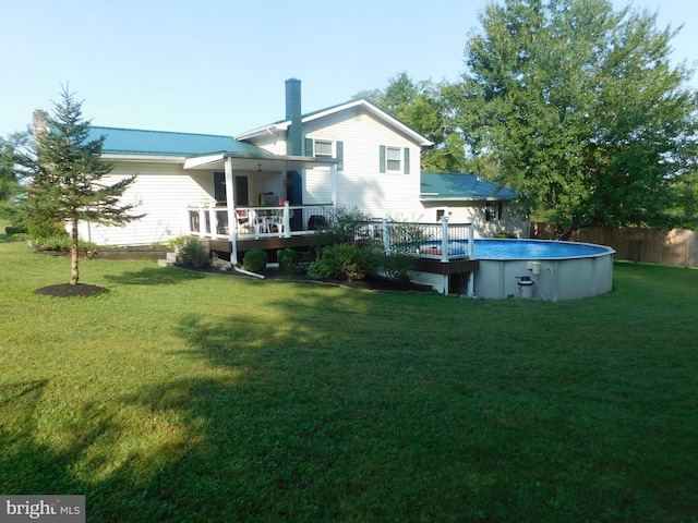 back of house with a lawn and a swimming pool side deck