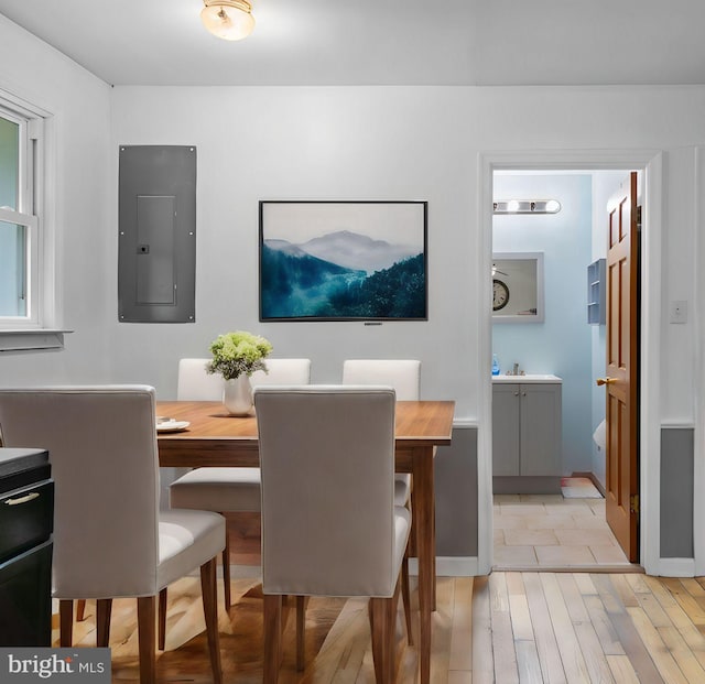 dining room with electric panel and light wood-type flooring