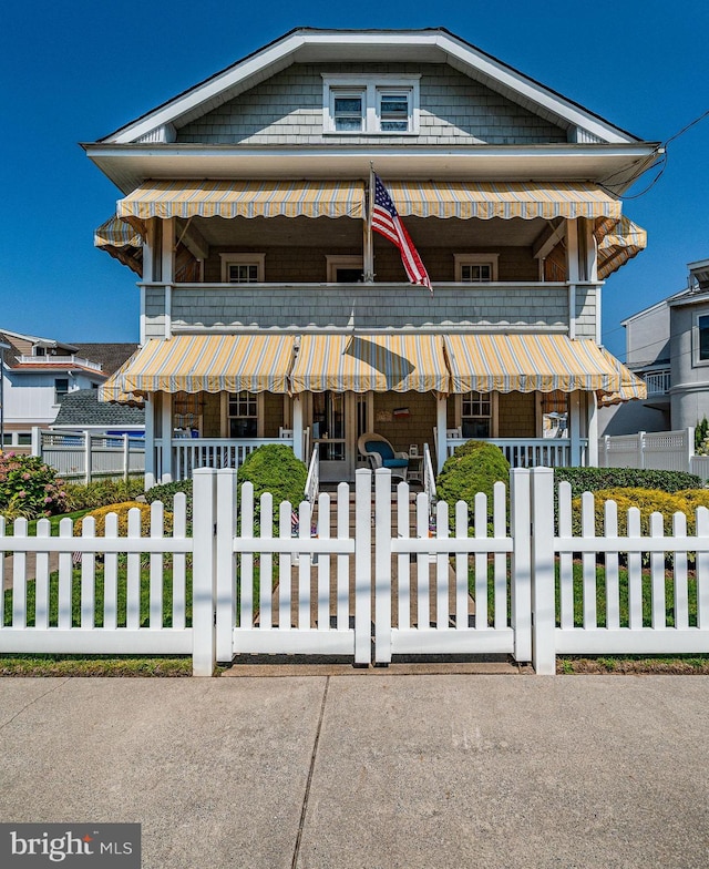 view of front of home with covered porch and a fenced front yard