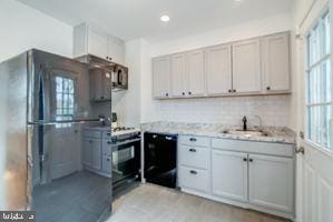 kitchen with black appliances, sink, and decorative backsplash