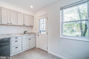 kitchen featuring black dishwasher, a healthy amount of sunlight, sink, and tasteful backsplash