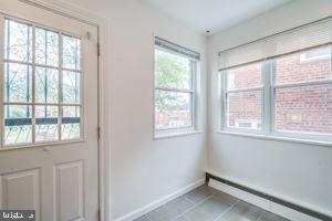 entryway with a baseboard heating unit and tile patterned floors