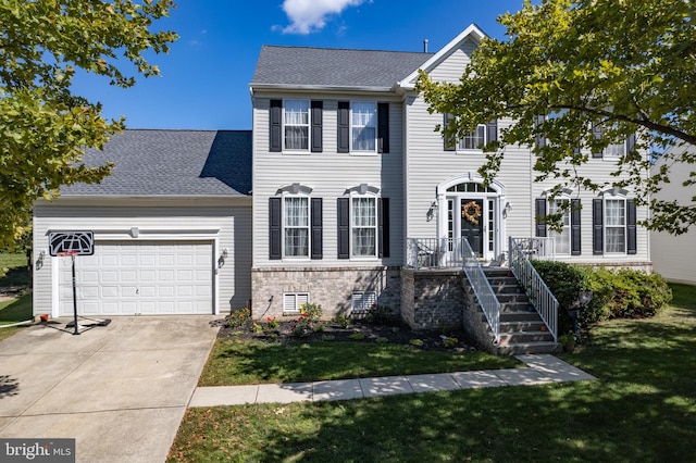 colonial-style house featuring a garage and a front lawn