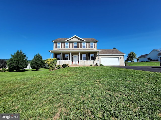 colonial inspired home with a garage, a front lawn, and a porch