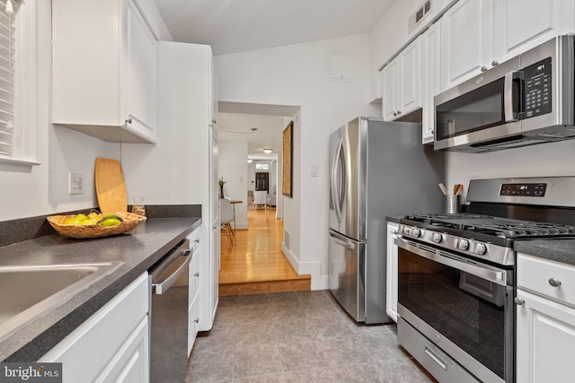 kitchen featuring appliances with stainless steel finishes, white cabinetry, and light hardwood / wood-style floors