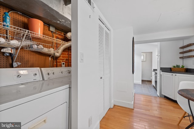 washroom featuring light wood-type flooring and washing machine and dryer