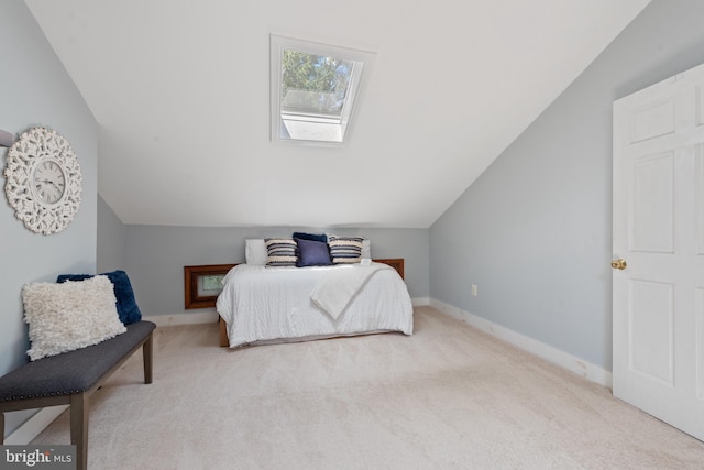 bedroom featuring light colored carpet and vaulted ceiling with skylight