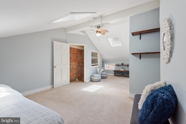 carpeted bedroom with vaulted ceiling with skylight and ceiling fan