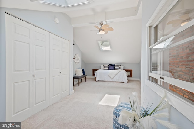 bedroom with lofted ceiling, a closet, ceiling fan, and light carpet