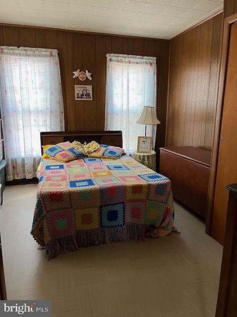 bedroom featuring wooden walls