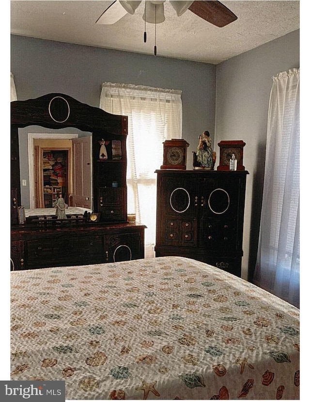 bedroom featuring ceiling fan and a textured ceiling