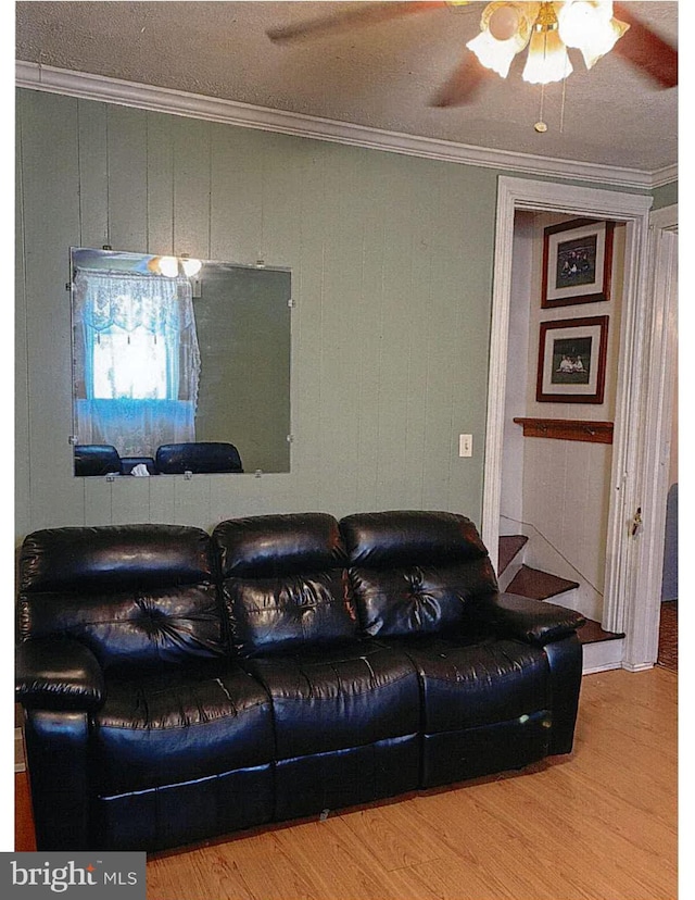 living room featuring ceiling fan, wood-type flooring, and ornamental molding