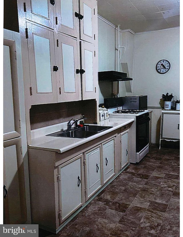 kitchen with white range with gas stovetop, white cabinets, and sink