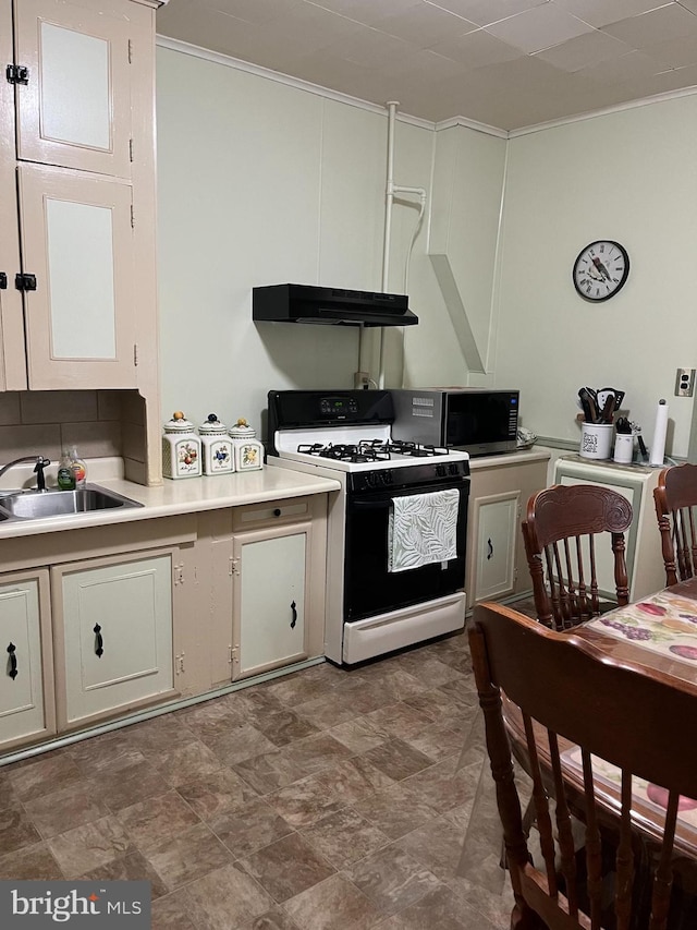 kitchen with white gas range, crown molding, and sink