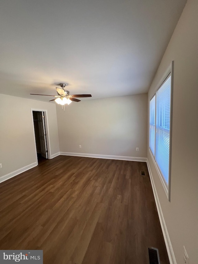 spare room featuring ceiling fan and dark wood-type flooring