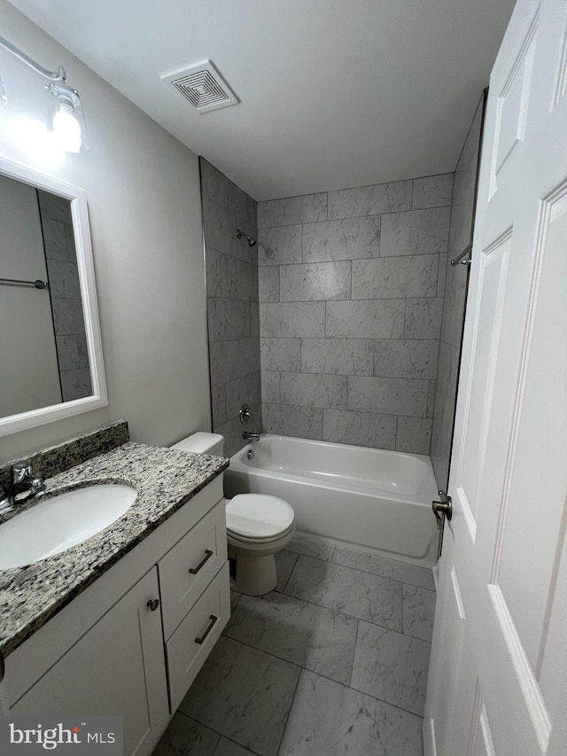 full bathroom featuring vanity, tiled shower / bath combo, and toilet