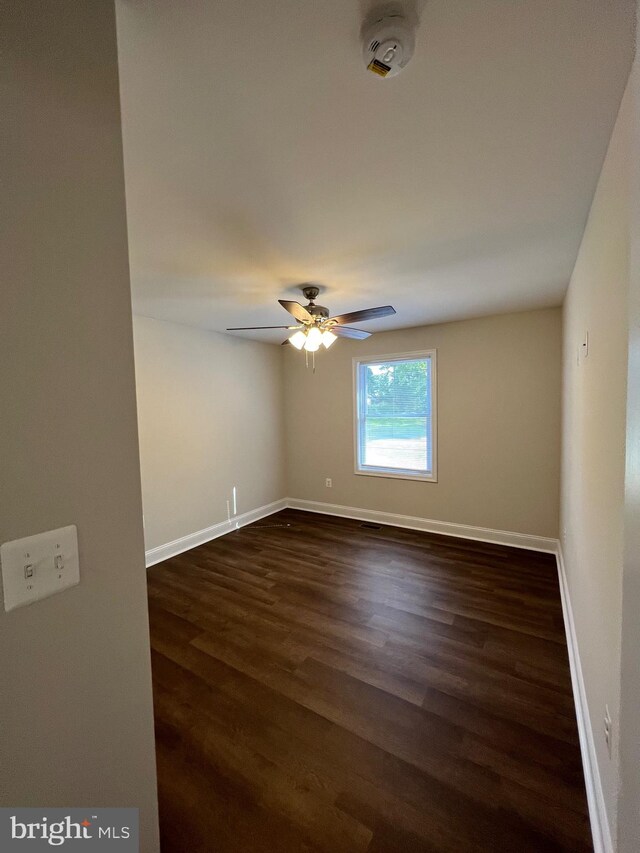 empty room with ceiling fan and dark hardwood / wood-style floors