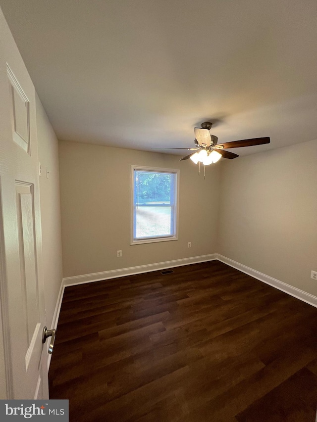 spare room featuring ceiling fan and dark wood-type flooring